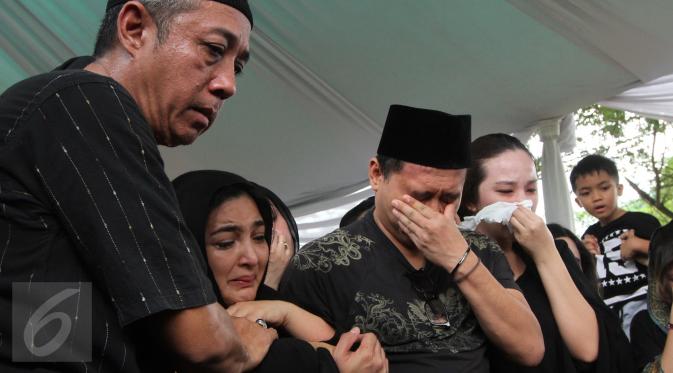 Penyanyi Ashanty didampangi suaminya, Anang Hermansyah terlihat menangis selama prosesi pemakaman sang ibunda, Ratu Farida, di TPU Jeruk Purut, Jakarta, Senin (7/11). Ibunda Ashanty meninggal dunia di usia 72 tahun. (Liputan6.com/Herman Zakharia)