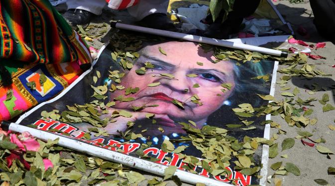 Dukun Peru melemparkan daun koka ke atas poster bergambar Capres AS dari Partai Demokrat, Hillary Clinton, saat melakukan ritual prediksi menjelang pemilihan presiden AS, di Lima, Peru, Senin (7/11). (REUTERS/Mariana Bazo)