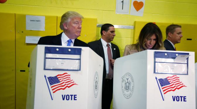 Calon Presiden AS dari partai Republik Donald Trump, saat melihat sang istri, Melania Trump menggunakan hak suaranya pada pemilu presiden di TPS 59, yang berlokasi di sebuah sekolah di Manhattan, New York, Selasa (8/11). (REUTERS/Carlo Allegri)