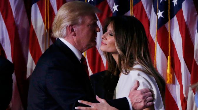 Presiden AS ke-45 Donald Trump mencium istrinya, Melania usai berpidato di hadapan pendukung di Manhattan, New York Rabu (9/11). Trump langsung menyampaikan pidato kemenangannya setelah meraih 288 electoral vote pada Pilpres AS. (REUTERS/Jonathan Ernst)