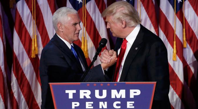 Presiden ke-45 AS Donald Trump dan Wakil Presiden Mike Pence berjabat tangan di hadapan pendukung di Manhattan, New York, Rabu (9/11). Trump berhasil mendapat suara electoral votest lebih dari 270 sebagai syarat kemenangan Pilpres AS. (REUTERS/Mike Segar)