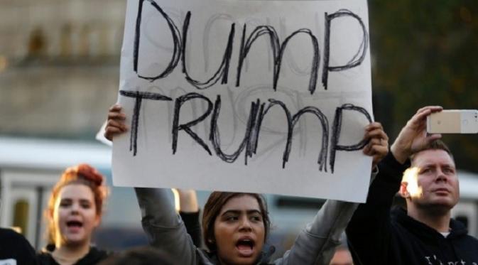 Pengunjuk rasa di Seattle mengusung spanduk bertuliskan, 'Dump Trump' (AP)
