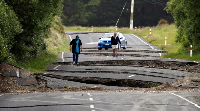Warga melihat jalan retak di jalan raya State Highway One, sebelah selatan dari Blenheim di Pulau Selatan, Selandia Baru, Senin (14/11). Gempa 7,8 SR yang mengguncang Selandia Baru mengakibatkan jalan tersebut retak. (REUTERS/Anthony Phelps)