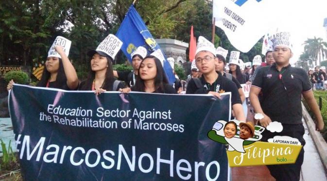 Mahasiswa melakukan demonstrasi di Manila, menentang pemberian gelar pahlawan kepada Presiden Ferdinand Marcos. Pada saat yang sama, Piala AFF 2016 digelar di Stadion Rizal Memorial. (Bola.com/Wiwig Prayugi)