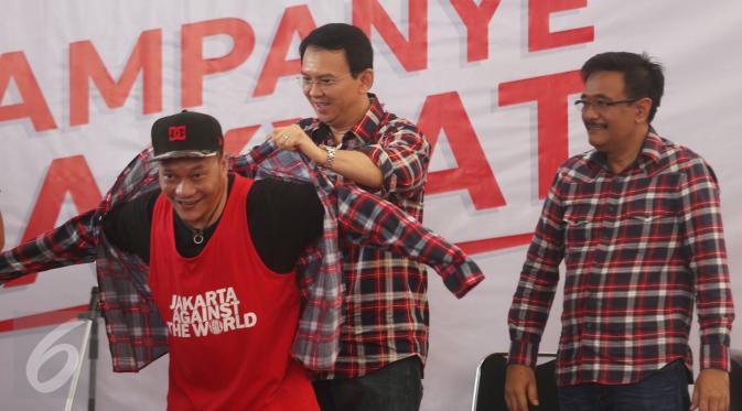 Cagub Basuki T Purnama dan Cawagub DKI Jakarta Djarot Saiful Hidayat memakaikan kemeja ke penyanyi rap Iwa K di Rumah Lembang, Jakarta, Senin (28/11). Sejumlah penyanyi rap turut meramaikan kampanye rakyat tersebut. (Liputan6.com/Immanuel Antonius)