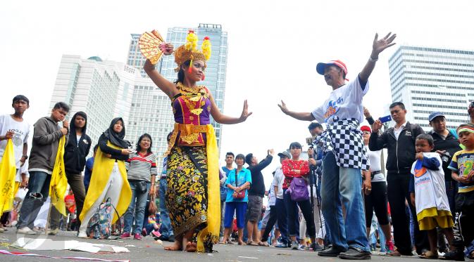 Seorang peserta ikut menari Tari Pendet khas Bali dalam parade kebudayaan bertajuk 'Kita Indonesia' di kawasan Bundaran HI, Jakarta, Minggu (4/12). Para peserta Parade Kebudayaan tampak antusias menyaksikan tarian itu. (Liputan6.com/Angga Yuniar)