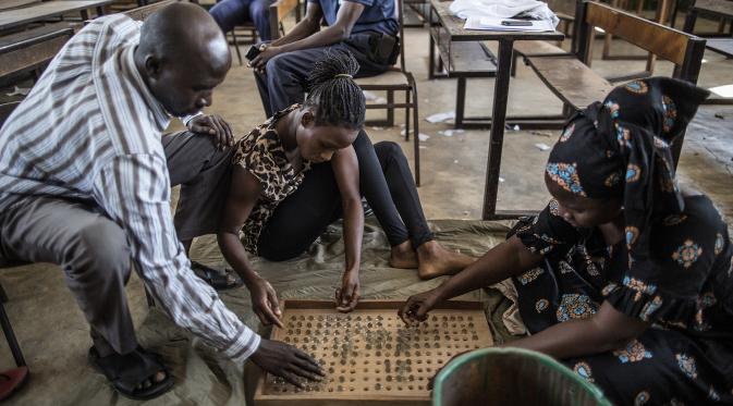Sejumlah petugas menghitung kelereng yang akan digunakan untuk pemilihan Presiden Gambia di distrik Tallinding, Serekunda, Gambia (30/11). Mekanisme pemungutan suaranya hampir sama dengan negara demokrasi lainnya. (AFP/Marco Longari)