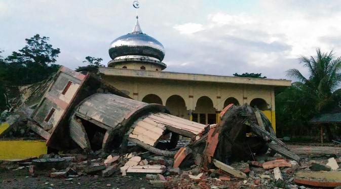 Sebuah menara masjid roboh menyusul gempa 6,4 SR yang mengguncang Kabupaten Pidie Jaya, Aceh, Rabu (7/12). Empat orang dikabarkan meninggal dunia dan sekitar 30 warga mengalami luka-luka akibat tertimpa bangunan roboh. (Zian Muttaqien/AFP)