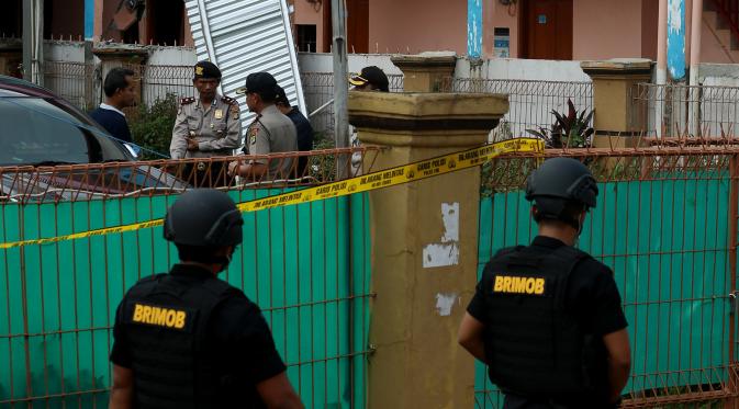 Petugas berjaga di sekitar rumah terduga anggota jaringan teroris, Bekasi, Minggu (11/12). Densus 88 menangkap tiga orang terduga anggota kelompok teroris dan menemukan bom siap ledak. (Liputan6.com/Johan Tallo)