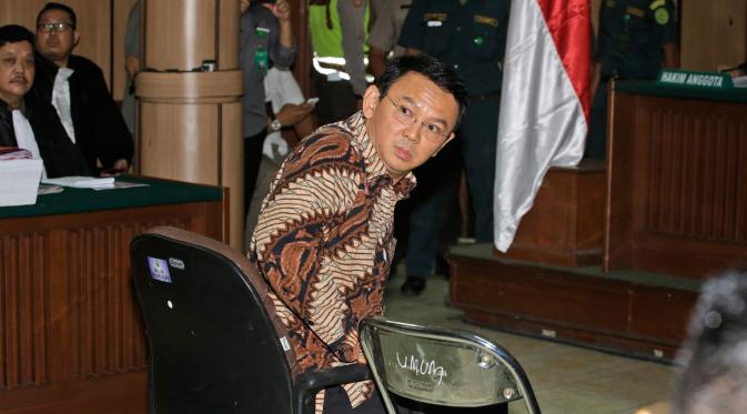 Basuki Tjahaja Purnama atau Ahok melihat ke arah fotografer sesaat sebelum menjalani sidang perdana kasus dugaan penistaan agama di PN Jakarta Utara, Selasa (13/12). Sidang hari ini beragenda pembacaan surat dakwaan dari tim JPU. (TATAN SYUFLANA/POOL/AFP)