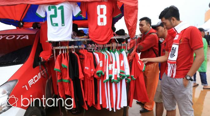 Tak hanya penjual minuman atau makanan, pedagang jas hujan pun meraup untung di final Piala AFF 2016 yang digelar di Stadion Pakansari. (Bintang.com/Adrian Putra)
