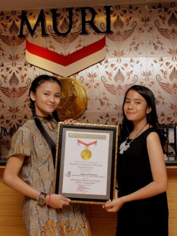 Dua bintang cilik pemeran film Ayu Anak Titipan Surga, Luthfiyah Putri dan Zila Zafila memegang plakat perhargaan dari MURI. (Istimewa)