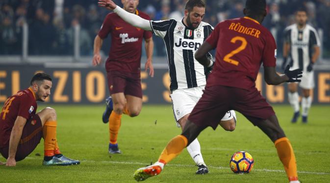Aksi penyerang Juventus, Gonzalo Higuain (tengah) di tengah tekanan para pemain AS Roma, pada lanjutan Serie A 2016-2017, di Juventus Stadium, Minggu (18/12/2016) dini hari WIB. (Reuters/Tony Gentile)
