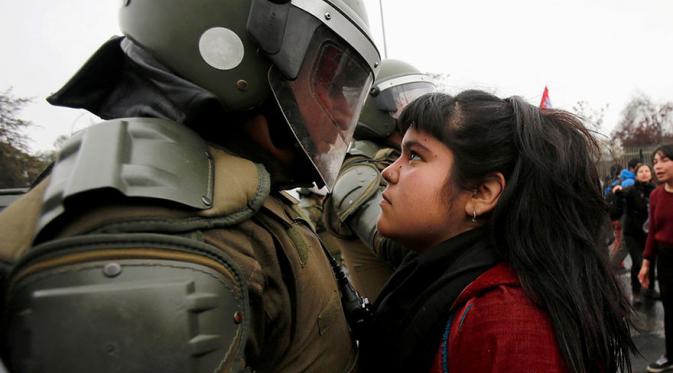 Seorang demonstran menghadang petugas di Santiago, Chili. (Via: boredpanda.com)