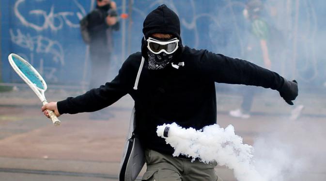 Seorang demonstran di Nantes, Perancis berusaha menangkis gas air mata. (Via: boredpanda.com)