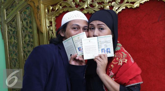 Ria Irawan bersama suaminya, Mayky Wongkar berpose menunjukan buku nikah usai Ijab Qabul di KUA Cilandak, Jakarta, Jumat (23/12). Akhirnya setelah 17 tahun menjanda, Ria menikah untuk kedua kalinya dengan asistennya sendiri. (Liputan6.com/Herman Zakharia)