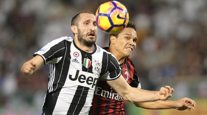 Bek Juventus, Giorgio Chiellini, berduel dengan striker AC Milan, Carlos Bacca, pada Piala Super Italia 2016. (AFP/Karim Jaafar)