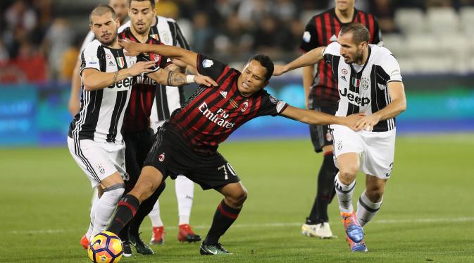 Striker AC Milan, Carlos Bacca, berusaha melewati kepungan pemain Juventus pada laga Piala Super Italia 2016. Juventus pada laga ini melakukan sembilan kali tembakan ke arah gawang, sementara AC Milan hanya enam kali. (AFP/Karim Jaafar)