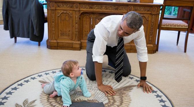 Barack Obama tengah merangkak bersama putri dari Communications Director Jen Psaki. (Foto: Pete Souza/DailyMail)