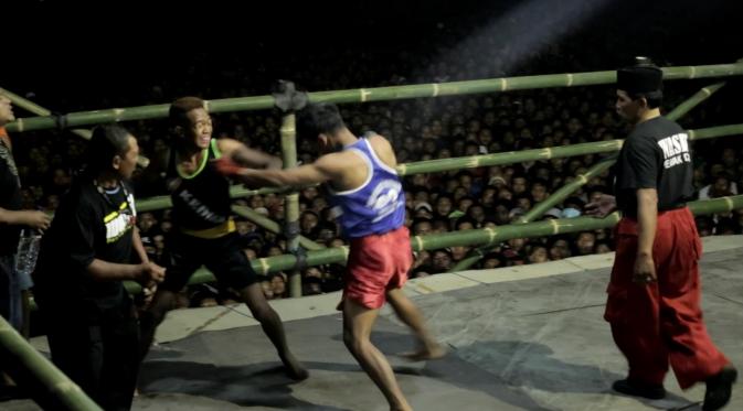 Seorang Petarung Mencoba Memukul Lawan di Arena Pencak Dor (Liputan6.com/Balgo Marbun) 