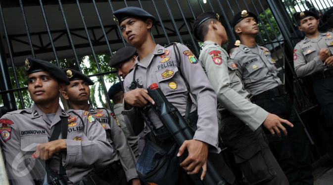 Petugas polisi membawa senapan gas air mata saat berjaga di depan Gedung Kementerian Pertanian, Jakarta, Selasa (3/1). Sedikitnya 2.500 personel kepolisian mengamankan sidang lanjutan Basuki Tjahaja Purnama (Ahok). (Liputan6.com/Helmi Afandi)