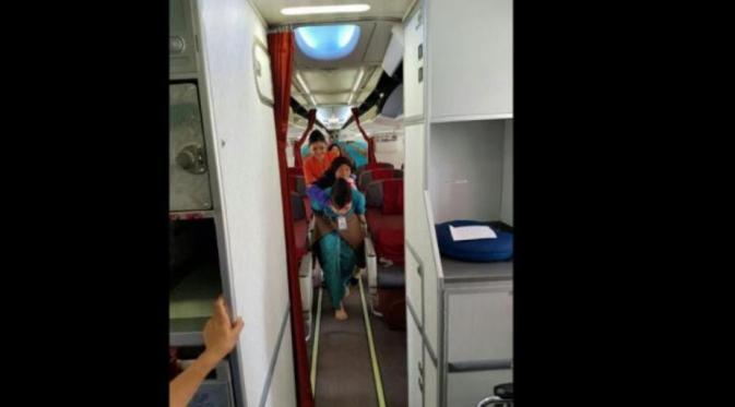 Foto Pramugari Garuda yang Gendong Seorang Nenek di Pesawat. (Foto: Istimewa)