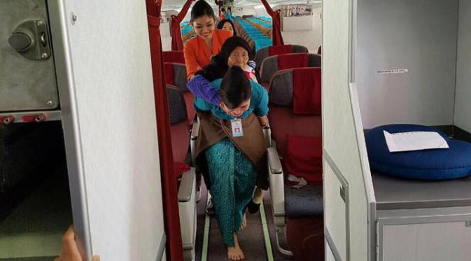 Foto pramugari Garuda Indonesia menggendong seorang nenek keluar pesawat menjadi viral. (Ist)