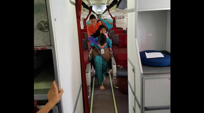 Foto pramugari Vera menggendong seorang nenek keluar pesawat menjadi viral. (Ist)