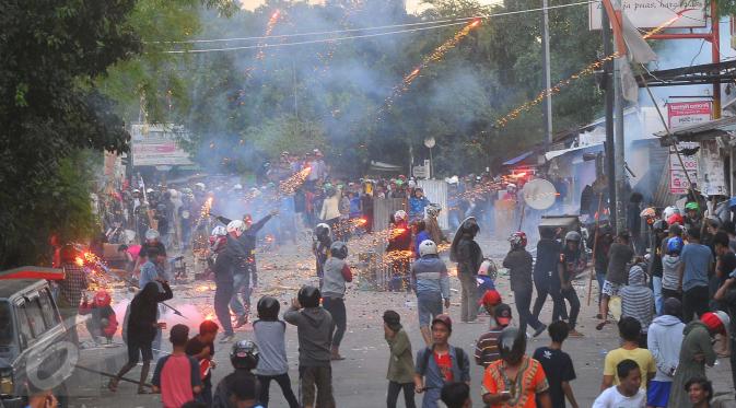 Tawuran antarwarga kembali pecah di dekat Stasiun Manggarai, Jakarta Selatan, Minggu (8/1). Mereka tampak membawa kayu dan saling lempar batu, sehingga membuat hamparan batu berserakan di jalanan. (Liputan6.com/Angga Yuniar)