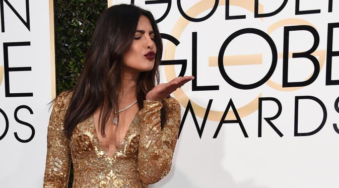Bintang Bollywood Priyanka Chopra memeriahkan gelaran red carpet Golden Globe 2017 di California, Minggu (8/1). Priyanka tampil memukau mengenakan gaun panjang warna emas dari Ralph Lauren yang berbelahan dada rendah. (Jordan Strauss/Invision/AP)