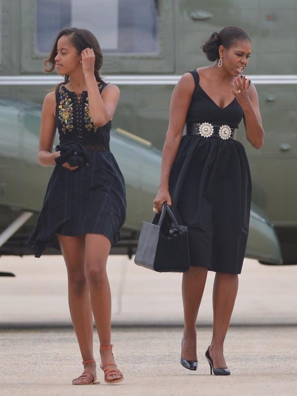 Malia Obama mengenakan flare dress hitam serupa dengan ibunya, Michelle Obama. Sumber: popsugar.com.