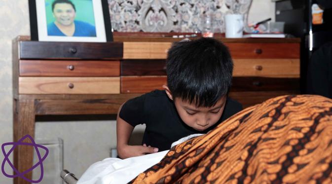 Putra bungsu Oon Project Pop, ikut mencium kening ayahnya untuk yang terakhir kali. (Deki Prayoga/Bintang.com)