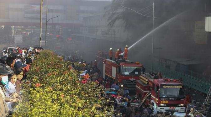 Warga tampak ramai ingin melihat proses pemadaman kebakaran yang melanda pusat perbelanjaan Pasar Senen, Jakarta Pusat, Kamis (19/1). (Liputan6.com/Faizal Fanani)