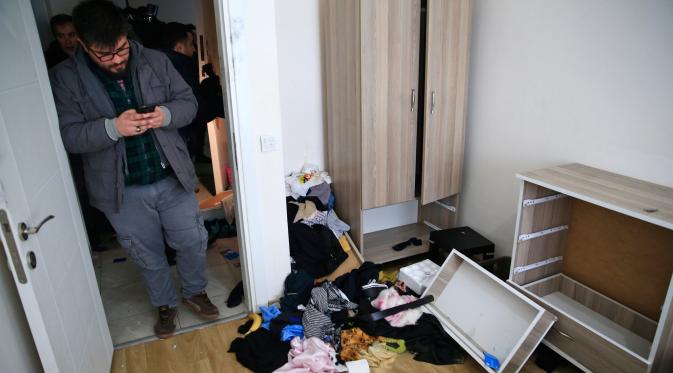 Petugas berpakaian preman berjalan di dalam apartemen di mana tersangka serangan klub malam Tahun Baru ditangkap di Istanbul, Turki, 17 Januari 2017. Pria bersenjata bernama Abdulkadir Masharipov membunuh 39 orang dalam serangan. (AP/Lefteris Pitarakis)