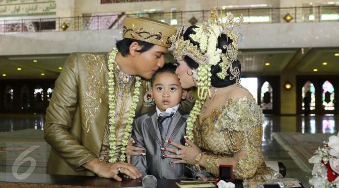 Lucky Hakim dan Tiara Dewi mencium anak Tiara Dewi seusai akad nikah di Masjid At Tin, Jakarta, Kamis (19/1/). Pernikahan Lucky dan Tiara berlangsung sederhana dan tak banyak kerabat dan tamu undangan yang hadir. (Liputan6.com/Herman Zakharia)