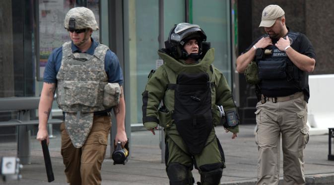 Penjinak bom berjalan usai mengambil paket mencurigakan di dekat Hilton Garden Hotel di Washington, DC.AS (19/1). Sekitar 28.000 pasukan keamanan akan berjaga saat pelantikan Presiden terpilih AS, Donald Trump. (AFP Photo/Andrew Caballero-Reynolds)