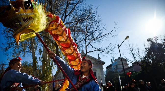 Sejumlah orang membawakan tarian Naga saat perayaan menjelang tahun baru China di Lisbon, Portugal (21/1).  Menjelang Imlek, warga keturunan Tionghoa di Portugal juga merayakannya dengan karnaval di sekitar Kota Lisbon. (AFP/Patricia De Melo Moreira)