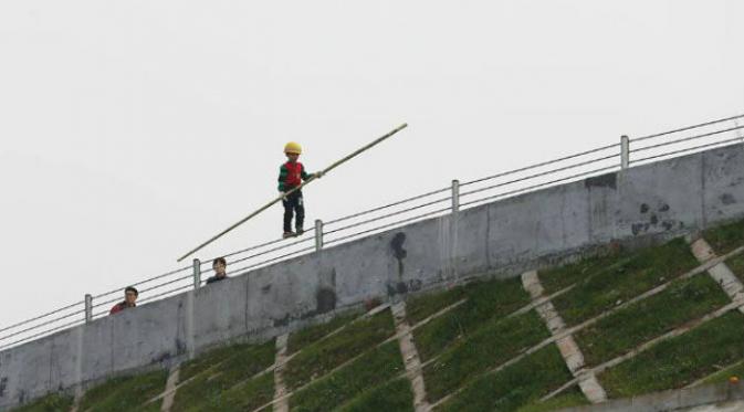 Aksi ekstrem yang dilakukan seorang bocah China dengan meniti seutas tali pada ketinggian tertentu membuat banyak orang kagum.(Shanghaiist.com)