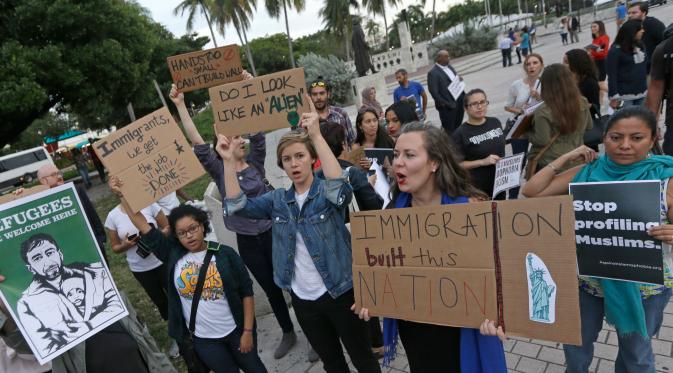 Pengunjuk rasa berkumpul di pusat kota Miami, AS, Kamis (26/1). Pengunjuk rasa menolak kebijakan Presiden AS, Donald Trump yang membatasi warga Muslim masuk ke AS. (AP Photo / Alan Diaz)