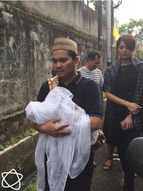 Indra Bekti menggendong jenazah putra ketiganya. (Rivan Yuristiawan/Bintang.com)