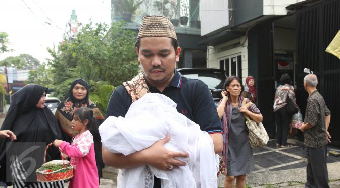 Presenter Indra Bekti menggendong jenazah anak ketiganya menuju TPU Kamboja, Radio Dalam,  Jakarta, Rabu (1/2). Anak ketiga pasangan Indra Bekti dan Aldilla Jelita itu meninggal beberapa menit setelah dilahirkan. (Liputan6.com/Herman Zakharia)