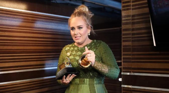 Dalam ajang bergengsi Grammy Awards 2017, Adele memang berhasil membawa pulang lima piala kemenangan dalam lima nominasi. Namun saat menerima salah satu piala, di atas panggung Adele malah melakukan hal yang tak disangka. (AFP/Bintang.com)
