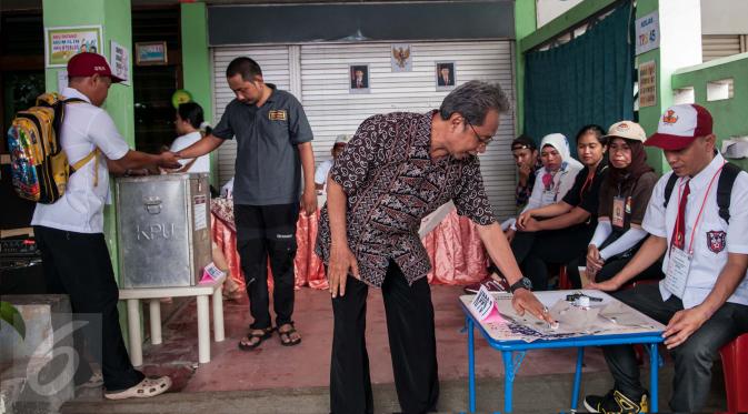 Warga menggunakan hak pilihnya pada Pilkada DKI 2017 di TPS 45 Kelurahan Kebon Pala, Jakarta, Rabu (15/2). Petugas di TPS tersebut menggunakan kostum seragam sekolah dasar untuk menarik warga datang ke TPS. (Liputan6.com/Gempur M Surya)