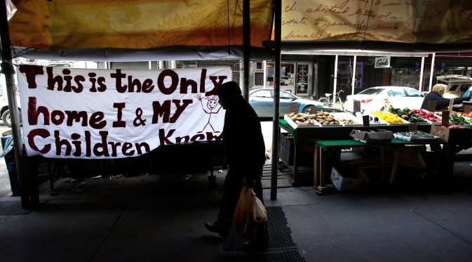 Pejalan kaki melewati spanduk yang tergantung di luar sebuah toko di Philadelphia, Kamis (16/2). Para Imigran di AS berdiam diri di rumah sebagai bentuk protes kebijakan Donald Trump yang ingin mendeportasi para imigran. (AP Photo/Jacqueline Larma) 