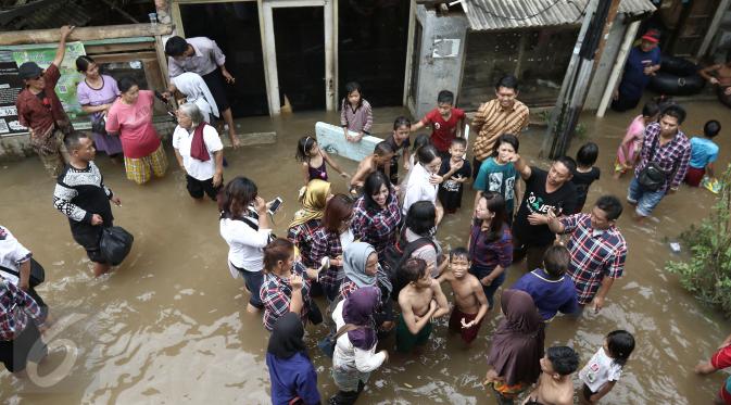 Cathy Sharon (berbaju putih) bersama Heppy Farida meninjau lokasi banjir di kawasan Pancoran, Jakarta Selatan, Selasa (21/02). Cathy Sharon dan Heppy Farida Djarot meninjau lokasi banjir dan menyalurkan sumbangan untuk korban banjir. (Liputan6.com/Herman Zakharia)
