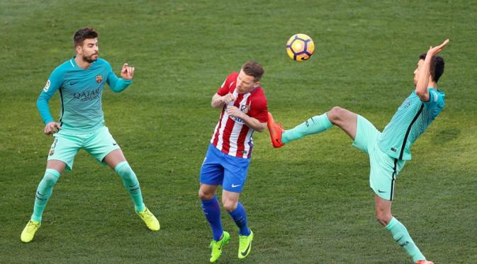  Pemain Barcelona, Gerard Pique dan Sergio Busquets mengawal ketat pemain Atletico. (AP Photo/Daniel Ochoa de Olza)
