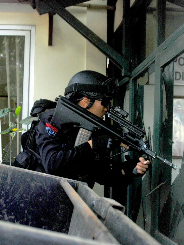 Penembak jitu mengambil posisi selama baku tembak dengan terduga pelaku ledakan bom panci di dalam kantor Kelurahan Arjuna, Kecamatan Cicendo, Bandung, Senin (27/2). Setelah meledakkan bom panci, pelaku masuk ke dalam kantor kelurahan (Timor Matahari/AFP)