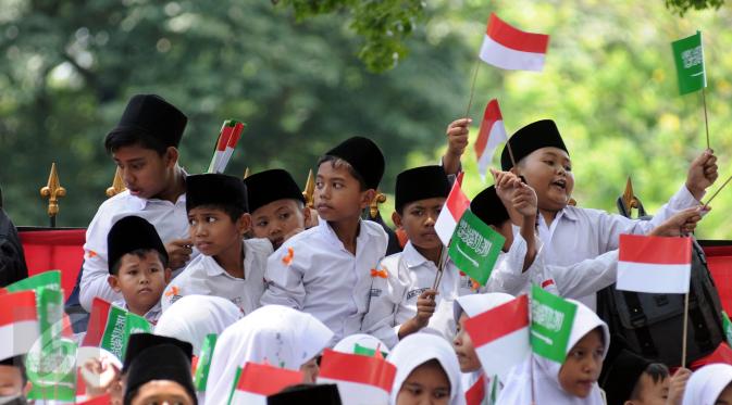 Sejumlah pelajar mengibarkan bendera kedua negara untuk menyambut kedatangan Raja Salman bin Abdulaziz di sekitar Istana Bogor, Rabu (1/3). 21 dentuman meriam dan kibaran bendera kedua negara mewarnai sambut Raja Salman. (/Helmi Fithriansyah)