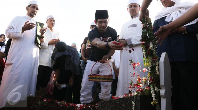  Aktor Iko Uwais menaburkan bunga di pemakaman ayahnya Musthafa Kamaluddin di TPU Prumpung, Jakarta, Rabu (8/3). Ayah Iko Uwais wafat pada  Rabu (8/3/2017) pagi di RSCM. (Liputan6.com/Herman Zakharia)