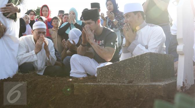 Aktor Iko Uwais berdoa di depan makam ayahnya Musthafa Kamaluddin di TPU Prumpung, Jakarta, Rabu (8/3). Ayahanda Iko Uwais itu meninggal dunia di usia 78 tahun karena sakit. (Liputan6.com/Herman Zakharia)